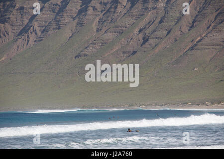 Surfer warten auf die perfekte Welle am Famara, Lanzarote. Stockfoto