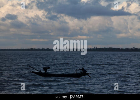 Fischer Angeln am Fluss Poshur mit einem Holzboot am Mongla. Bagerhat, Bangladesch. Stockfoto