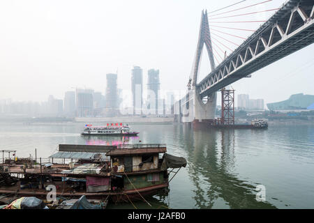 China, Chongqing, der Bau von massiven neuen Dongshuimen Brücke und in der Nähe Bürotürme entlang Yangtze-Fluss trüben Herbstnachmittag Stockfoto