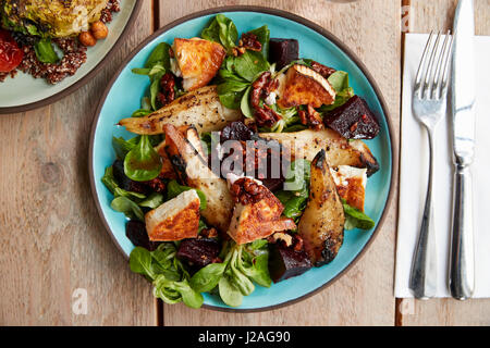 Ziegenkäse, Birne Salat am Tisch mit anderen Gericht, über Kopf Stockfoto