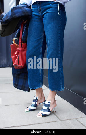 LONDON - Februar 2017: Niedrige Teil der Trägerin Dreiviertel Länge Jeans und Kätzchen Ferse gestreift Leder zehenoffenen Pantoletten stehen auf der Straße während der London Fashion Week, vertikale Stockfoto