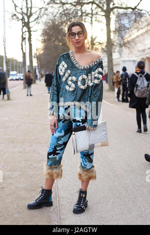 LONDON - Februar 2017: Volle Länge Blick auf weibliche Mode-Blogger tragen Ashish Hose und Oberteil, mit einer übergroßen Chanel Kupplung Handtasche Stand in der Straße, London Fashion Week, Tag vier. Stockfoto