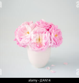 Kleine leichte rosa Strauß Rosen in Vase сeramic gegen blass grau hinterlegt.  Geringe Schärfentiefe. Selektiven Fokus Stockfoto