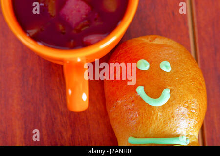 Elegante Einrichtung traditionelle leckere lateinamerikanische Guagua Brote, bunten Zucker Dekorationen, orange Cup mit Colada Morada-Beeren-Saft daneben, Tag der Toten Konzept Stockfoto