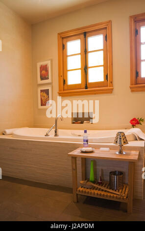 Badewanne und kleinen Holztisch im Badezimmer in einem gestapelten log home Stockfoto