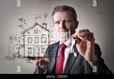 Geschäftsmann mit Schlüssel und gezeichnete Haus Stockfoto