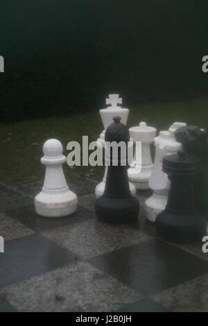 Große Schachfiguren an Bord im park Stockfoto