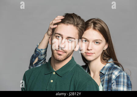 Porträt des jungen Paares stehen vor grauem Hintergrund Stockfoto