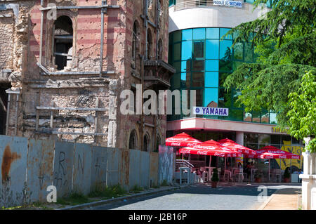 Mostar, Bosnien und Herzegowina, beschädigt Krieg Bau- und modernen neuen Block. Der Wiederaufbau nach dem Krieg. Stockfoto