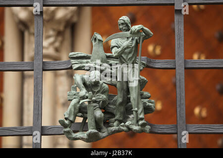 Bauer, Schärfen von Sensen vor der Zeit der Heuernte im Sommer. Allegorie der Jahreszeiten von tschechischer Bildhauer Jaroslav Horejc (1954-1957) für die dekorative Bronze Grille von der Golden Gate Saint Vitus Kathedrale in Prag, Tschechische Republik entworfen. Stockfoto