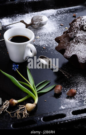 Tasse frischen Kaffee, hausgemachte Schokolade und Haselnuss Kuchen auf ein Backblech. Hautnah. Frühstück. Stockfoto