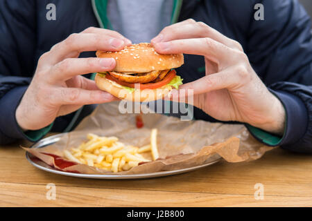 Nahaufnahme der Hände des Mannes mit amerikanischen Burger. Stockfoto