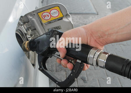 Bukarest, Rumänien, 5. Juni 2016: Nahaufnahme eines Menschen Hand mit einer Zapfsäule ein Auto mit Kraftstoff zu füllen. Stockfoto