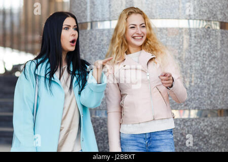 Zwei fröhliche Mädchen in der Nähe von Gebäude im Frühjahr Stockfoto