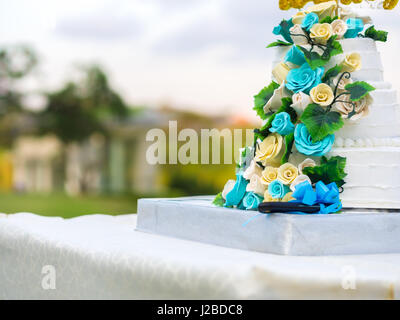 Wunderschöne Hochzeitstorte mit blauen und gelben Rosen Stockfoto