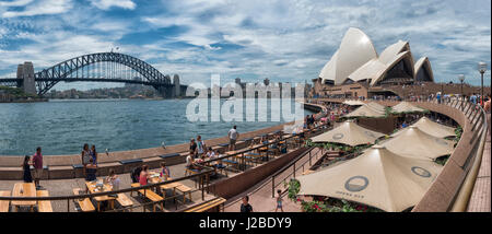 Ein Blick auf Sydneys berühmte Harbour Bridge und Opera House mit The Opera Bar in den Vordergrund und die North Shore im Hintergrund. Stockfoto