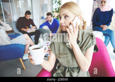 Business-Frau mit Kaffee mit einem Anruf Stockfoto