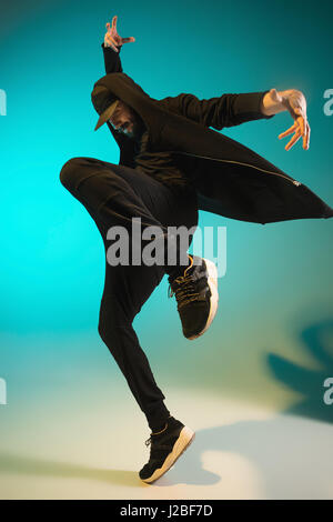 Die Silhouette von einem Hip-Hop-männliche Pause Tänzer tanzen auf farbigen Hintergrund Stockfoto