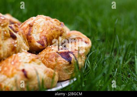 Hausgemachte Pasty mit Hackfleisch-Fleisch-Füllung, mit Sesam bestreut und serviert im Freien an einem sonnigen Tag Stockfoto