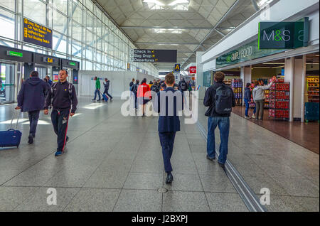 Passagiere, die zu Fuß in Richtung Abflug, Flughafen London-Stansted Stockfoto