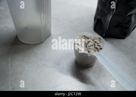 Molke-Protein-Pulver in Schaufel mit Tasche und Flasche Stockfoto