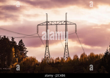 Übertragung der Strommast Silhouette gegen rote Himmel in der Abenddämmerung Stockfoto