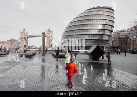 Spielende Kinder im Brunnen, mehr London, die Tower Bridge und die City Hall, South Bank, London, England Stockfoto