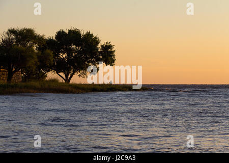 Man Fische in den Felsen von Colonia, Uruguay, an der Küste des Flusses La Plata. Stockfoto