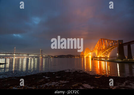 Die Forth Rail Bridge beleuchtet in der Abenddämmerung. South Queensferry, Edinburgh, Schottland Stockfoto