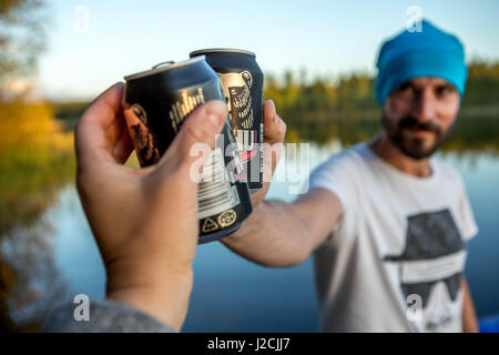 Finnland, 10 Tage in die Mökki, auf einer Insel Leben nur Ruderboot erreichbar. Ringelrobbe Nationalpark, Cheers mit finnischen Bier aus der Dose Stockfoto