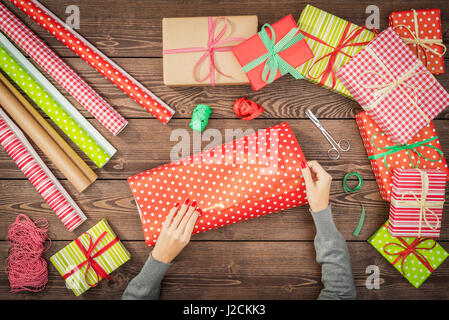 Weibliche Hände wickeln Weihnachtsgeschenke Stockfoto