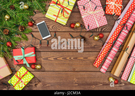 Weihnachtsvorbereitungen mit Geschenkboxen, Geschenkpapier und Baum auf hölzernen Tisch Stockfoto