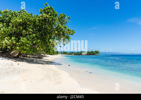 Indonesien, Maluku Utara, Kabupaten Halmahera Utara, Sandstrand unter blauem Himmel am nördlichen Molikken Stockfoto