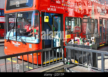 Rote Tourbus zieht an Bushaltestelle auf der Londoner Brücke neben Pflaster Kabinett als Müllkippe für Kaffee Tassen Getränkeflaschen & Dosen littering London Stockfoto