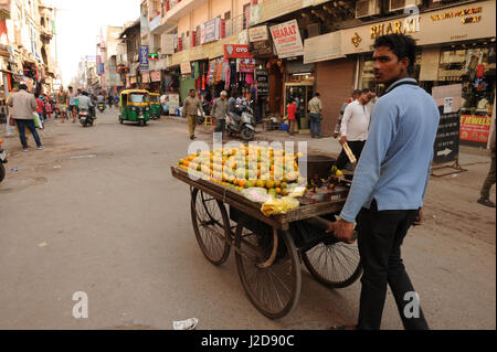 Ein Händler schiebt seine Karre von Obst durch Paharganj in Delhi, Indien Stockfoto