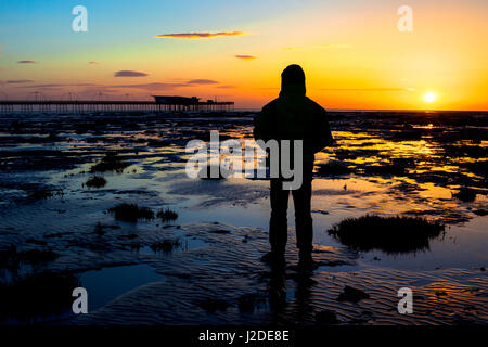 Southport, Merseyside, 27. April 2017. Großbritannien Wetter. Ein Mann sieht einen atemberaubenden Sonnenuntergang, wie es über den viktorianischen Pier in Southport in Merseyside ruht. Southport Pier ist ein Denkmalgeschütztes Gebäude an der Nordwestküste Englands. Im Jahre 1860 eröffnete es erstreckt sich über eine Länge von 1.108 Meter (3.635 ft) und ist das zweite längste in Großbritannien. Es wurde am 18. August 1975 am Grad II aufgeführten & noch zieht jedes Jahr Tausende von Besuchern. Bildnachweis: Cernan Elias/Alamy Live-Nachrichten Stockfoto