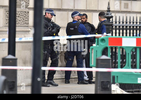 Bewaffnete Polizei sprechen Mann am Tatort, nachdem eine Person verhaftet worden war, nach einem Zwischenfall in Whitehall in London. Stockfoto