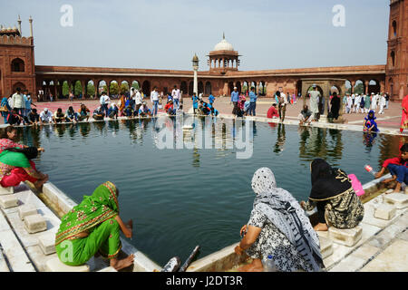 Muslimische Frauen und Männer nach dem Freitagsgebet waschen im Becken in Jama Masjid Moschee, Alt-Delhi, Indien Stockfoto