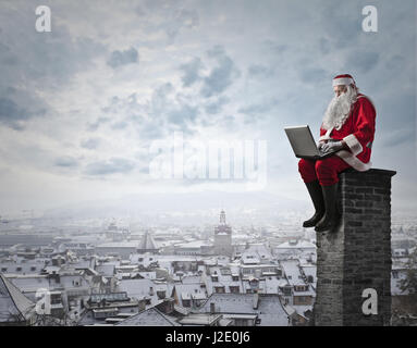 Santa Claus am Kamin sitzen Stockfoto