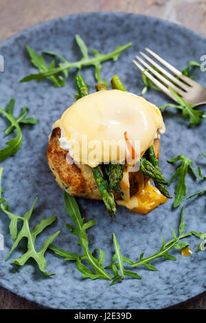 Fischfrikadellen mit Spargel, Spiegelei und Sauce Hollandaise Stockfoto