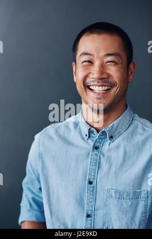 Junge asiatische Designer lächelnd souverän in einem Büro Stockfoto