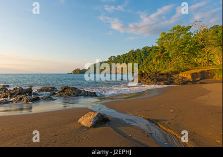 Landschaft eines Sonnenuntergangs in Costa Rica mit seiner üppigen Dschungel-Vegetation am Eingang des Corcovado National Park entlang des Pazifischen Ozeans. Stockfoto