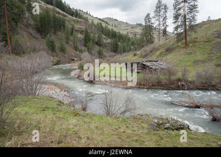 Log-Scheune entlang des Joseph Creek im nordöstlichen Oregon. Stockfoto