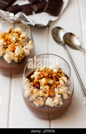 Heiße Schokolade im Glas mit Popcorn auf Tisch Stockfoto