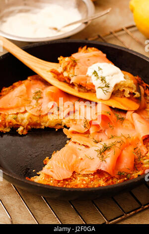 Kartoffel-Pizza mit Lachs und Sahne in schwarze Pfanne Stockfoto