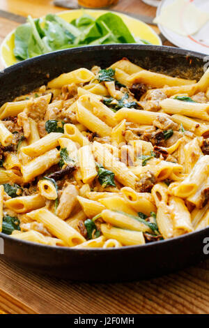 Penne mit Sonne getrockneten Tomaten, Huhn und Spinat Stockfoto