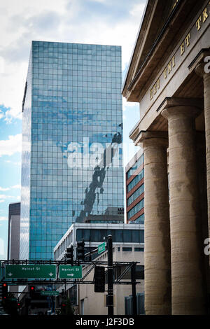 Straßenansicht in Nussbaum und Memorial Straßen in der Innenstadt von St. Louis, Missouri. Ein Teil des Gateway Arch spiegelt sich im Glas. Stockfoto