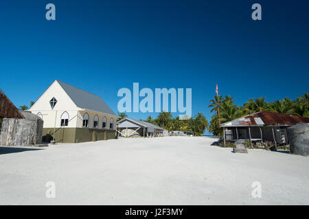 Cook-Inseln. Palmerston Insel. Aktuelle Bevölkerung von 62 Personen, alle Nachkommen von William Marsters (aka Meister). Main Street, Kirche und Wasserspeicherung (L) und Marsters historisches Haus (R). Stockfoto