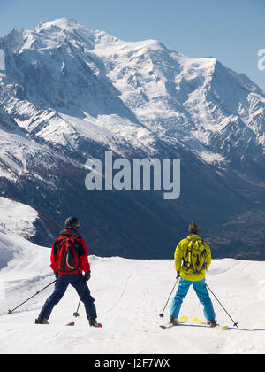 Zwei Skifahrer die Piste in Richtung Mont Blanc und Chamonix-Tal gleiten Stockfoto