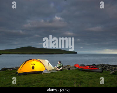 Mann mit Kajak in der Nähe der Tölpel Insel Noss auf den Shetland-Inseln, Schottland camping. Nordsee Stockfoto